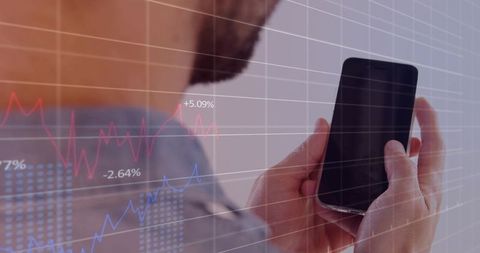 Businessman checking smartphone while analyzing financial charts and stock market data