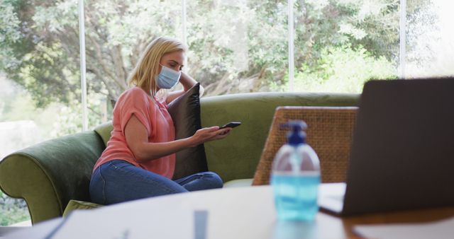 Woman Wearing Mask Relaxing on Sofa with Phone at Home - Download Free Stock Images Pikwizard.com