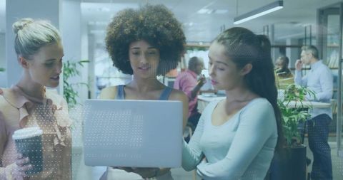 Diverse women collaborating in modern office with technology