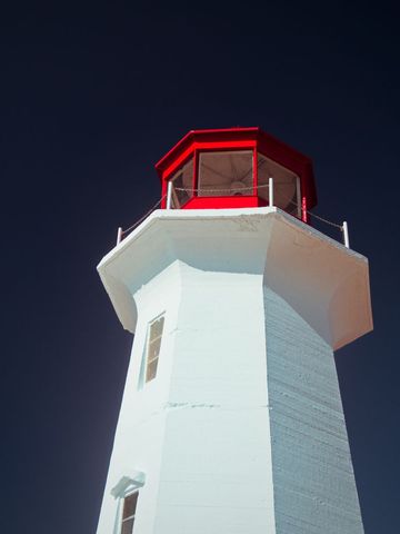 Majestic white lighthouse against deep blue sky