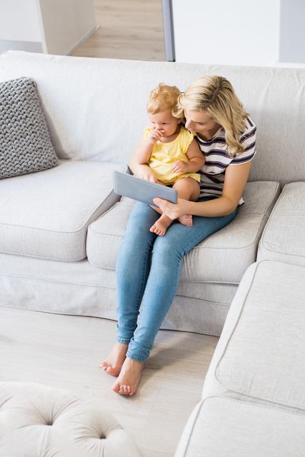 Mother and Baby Girl Using Tablet on Couch - Download Free Stock Photos Pikwizard.com