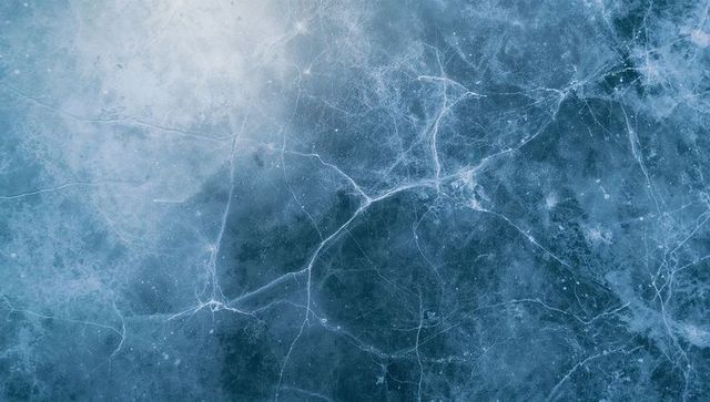 Cracked blue ice surface with fractal fissures and frosted network texture for background
