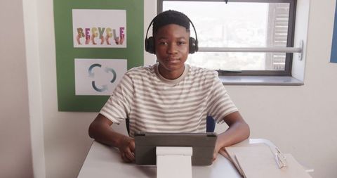 Tech-Savvy African American Boy Learning with Tablet in Eco-Friendly Classroom