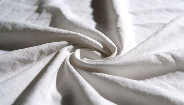 Displaying white cotton fabric spiral with detailed weave texture macro textile background