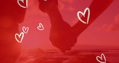 Romantic beach handholding with heart symbols