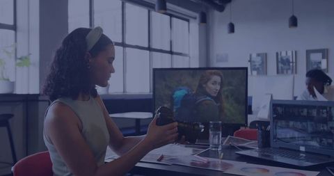 Professional woman adjusting dslr camera in modern office workspace