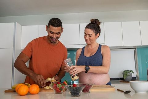 Diverse Couple Preparing Healthy Smoothie at Home Kitchen