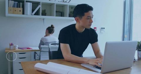 Focused Professional Working on Laptop in Modern Office Space