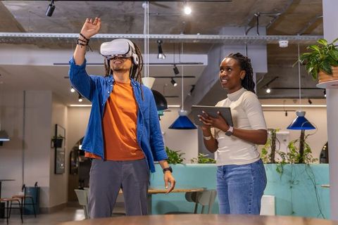 Multiracial coworkers testing virtual reality interface in modern collaborative office