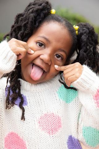 Joyful Little Girl Making a Playful Face Outdoors