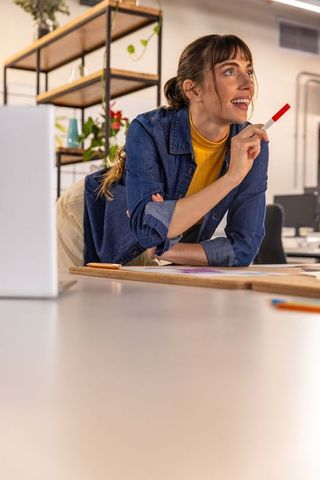 Woman in Modern Office Brainstorming with Red Marker