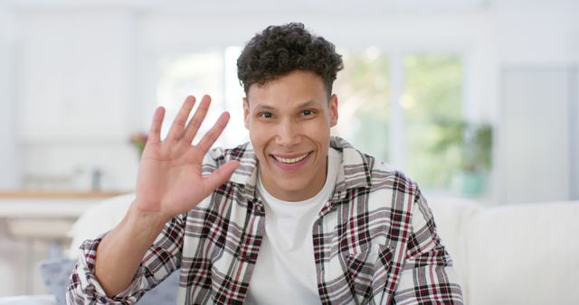 Smiling Man Greeting with Hand Wave in Living Room - Download Free Stock Images Pikwizard.com