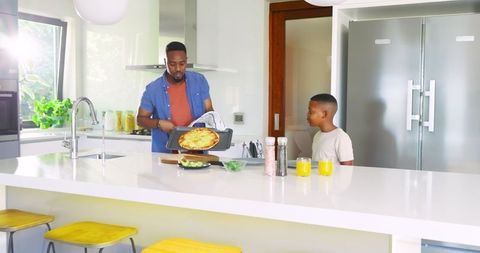 Father and Son Bonding Over Making Pizza in Modern Kitchen
