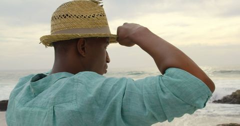 Man in Straw Hat Gazing at Ocean Horizon