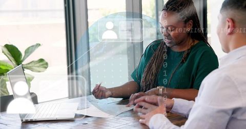 Collaborating on documents and laptop during business meeting in bright modern workspace