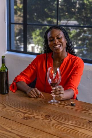 Elegant Woman Enjoying Wine in Vibrant Red Blouse