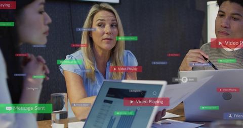 Presenting team leader in boardroom meeting with digital ui overlays and laptops