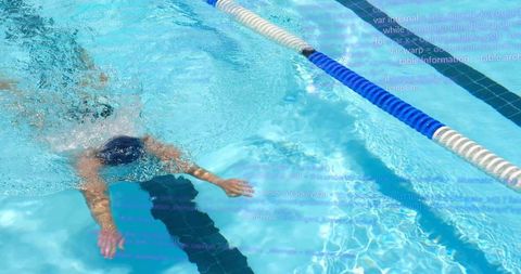 Male swimmer performing freestyle stroke in sunlit outdoor pool passing lane rope