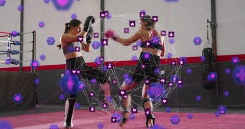 Female kickboxers sparring with augmented reality performance overlay in gym ring