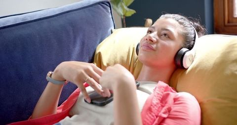 Teen Relaxing With Headphones on Cozy Couch