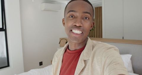 Young Man Capturing Selfie Moment in Minimalist Bedroom