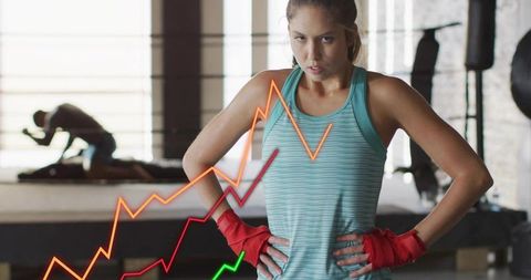 Female boxer catching breath after intense workout, teal tank, red wraps, performance graph overlay