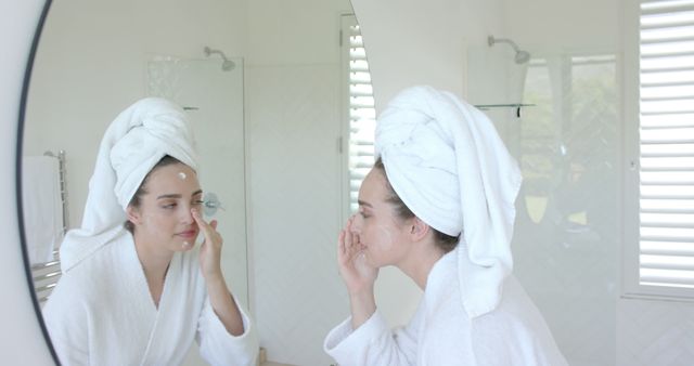 Woman in White Robe Applying Facial Cream in Bathroom - Download Free Stock Images Pikwizard.com