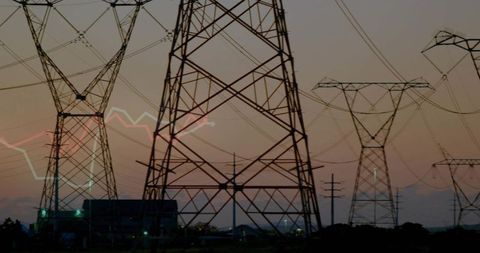 Powergrid towers in scenic dawn sky with substation