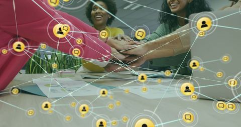 Diverse Team Shows Unity with Hands Stacked at Workspace