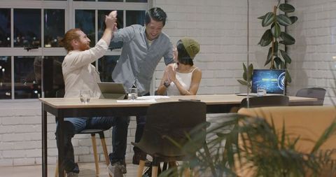 Diverse Team Celebrating Success in Night Office