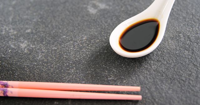 Close-Up of Soy Sauce in Ceramic Spoon with Pair of Chopsticks - Download Free Stock Images Pikwizard.com