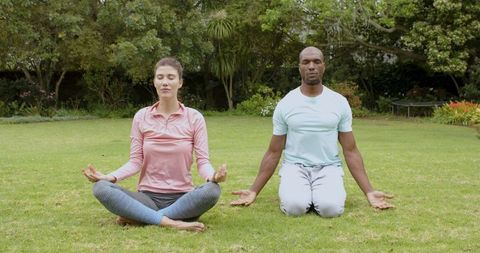 Diverse Pair Meditating in Tranquil Outdoor Park