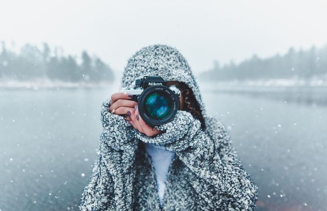 Close-up Portrait of Woman Holding Camera Against Lake during Winter - Download Free Stock Photos Pikwizard.com