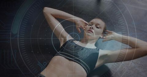 Female athlete performing crunches on mat with futuristic hud fitness overlay