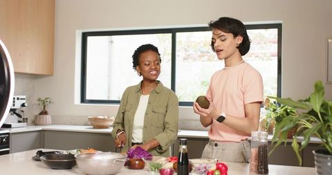Diverse creators chopping purple cabbage and prepping avocado for healthy cooking tutorial