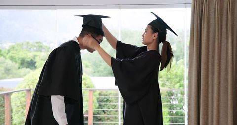 Graduating Couple Celebrating Diploma Success at Home