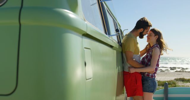 Young couple kissing near van on a sunny day. Couple romancing on the beach 4k