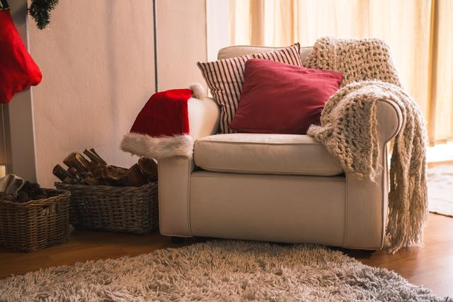 Woolen blanket, pillow and santa hat on sofa chair in living room at home