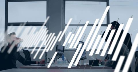 Collaborative team working at open office desk with laptops, coffee and modern workspace