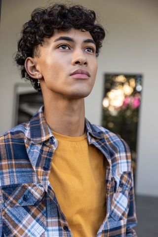 Fashionable Young Man Gazing Upward in Urban Environment