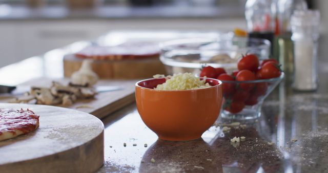 Image of bowls of tomatoes and grated cheese with pizza bases on kitchen counter - Download Free Stock Photos Pikwizard.com