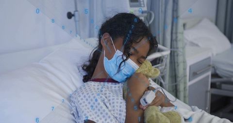 Child resting in hospital bed wearing mask and holding teddy bear for pediatric recovery