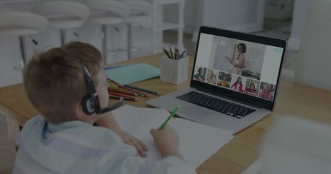Young Boy Attending Online Class From Home Desk