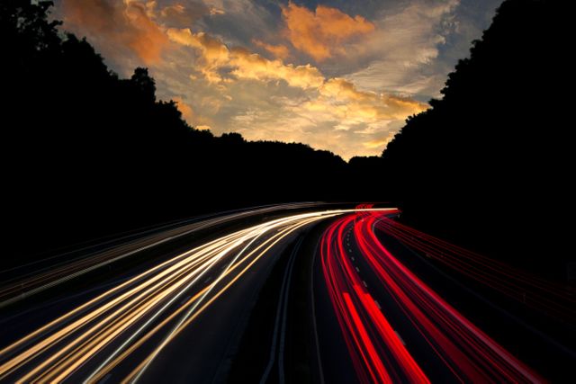 This photo captures light trails from cars on a highway at sunset, showing the movement of traffic using long exposure technique. Can be used to depict concepts of speed, motion, transportation, urban life, and night scenery. Ideal for blog posts, travel articles, transportation websites, and social media graphics related to city life and road travel.