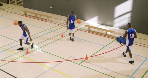 African american basketball players practicing dribbling cone drill for ball control