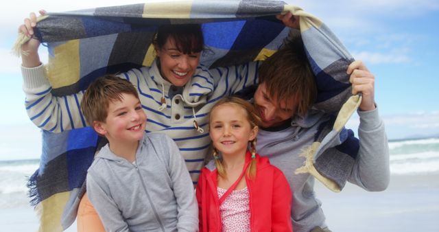 Happy Family at Beach Enjoying Togetherness Under Blanket - Download Free Stock Images Pikwizard.com