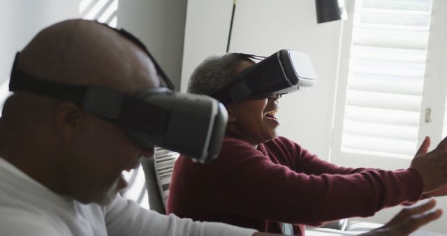 Seniors are using VR headsets and having a joyful experience. They engage with technology, showcasing they can be tech-savvy and adaptive to new innovations. Use in articles or advertisements focusing on senior use of technology, health and well-being programs for elderly individuals, or promoting inclusive tech environments.
