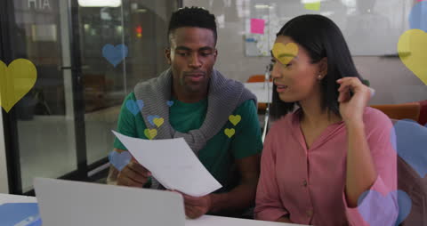 Colleagues Analyzing Data with Heart Icons Overlay