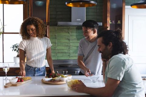 Friends Gathering Around Kitchen Island Sharing Charcuterie Board and Wine