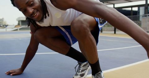 Basketball Player Kneeling on Urban Court during Practice